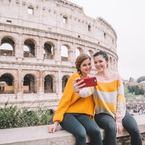Two participants sit outside of the Colosseum in Rome